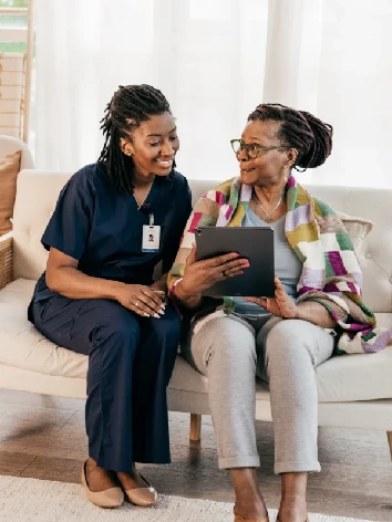 Care professional providing personalized support and companionship to a senior woman at Elite Care Assisted Living Facility in Lakeland, Florida.