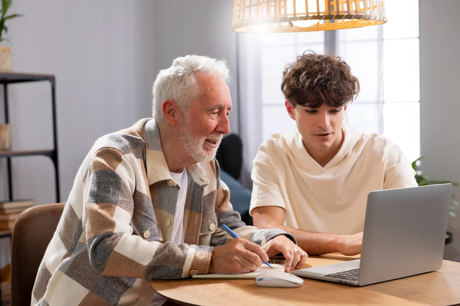 An elderly man engaging in a learning session with a younger assistant at an assisted living facility.