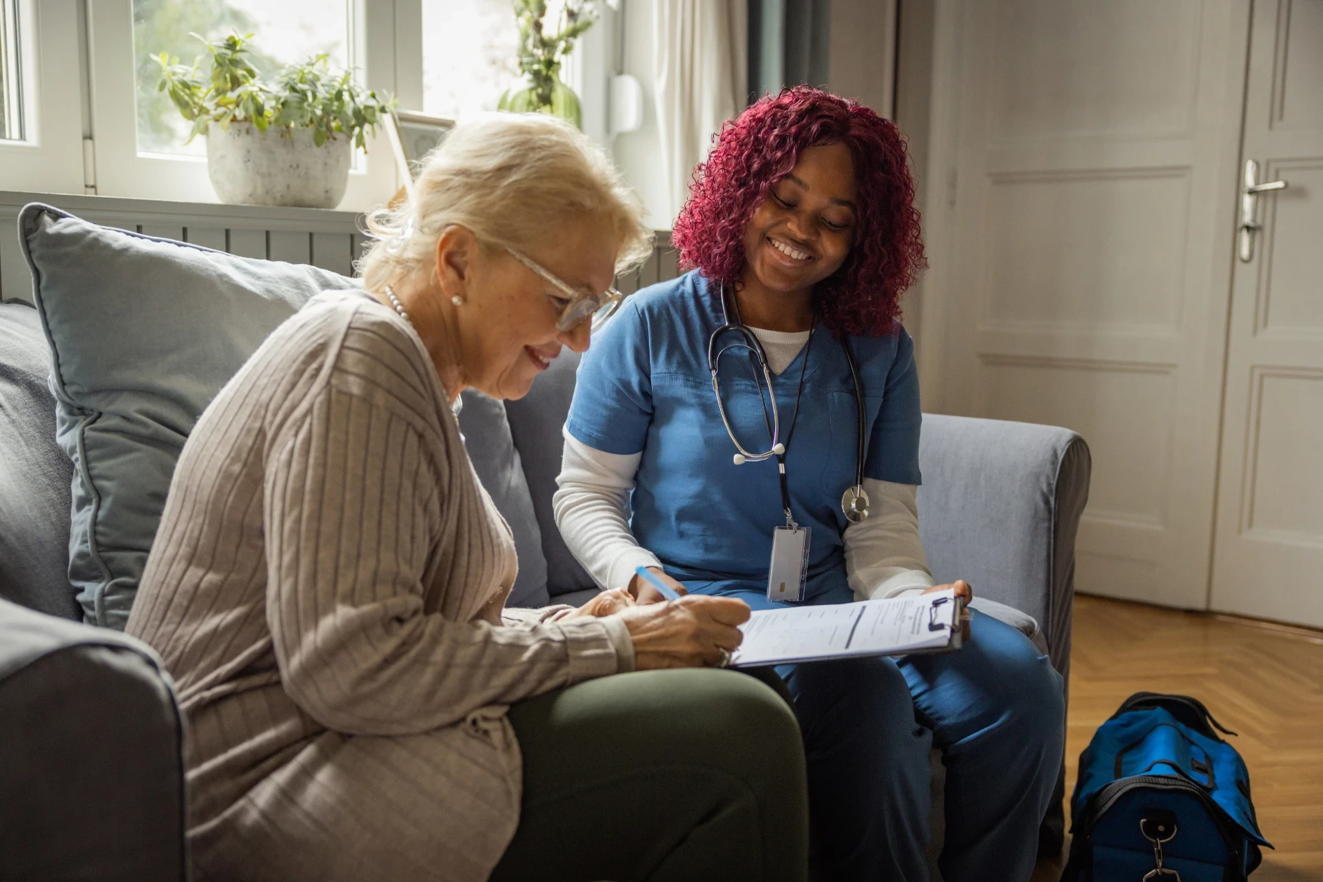 Nurse assisting a senior woman with medication management at Elite Care Assisted Living Facility in Lakeland, Florida.