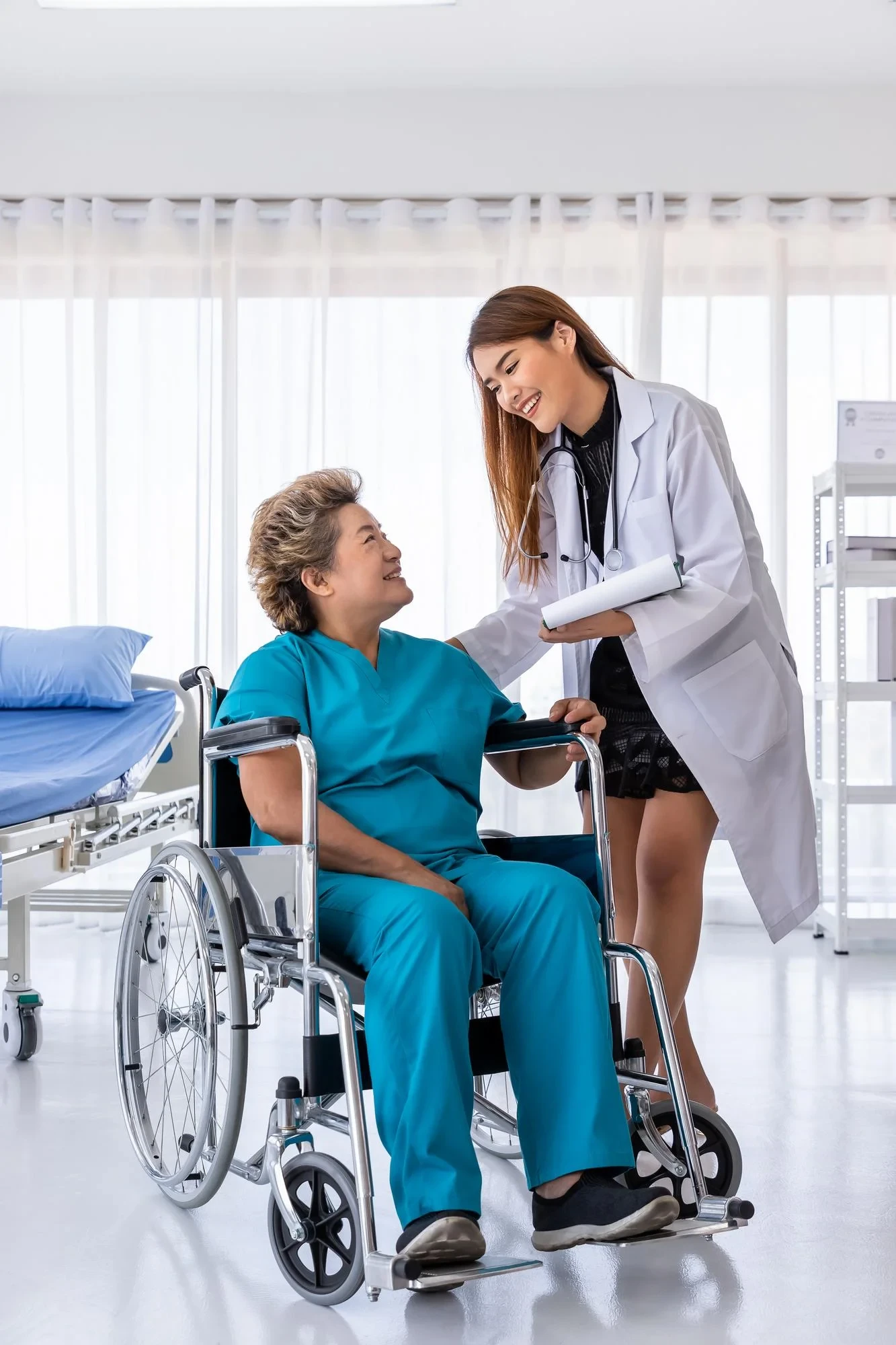 Nurse assisting an elderly woman in a wheelchair, providing skilled medical assistance and personalized care.
