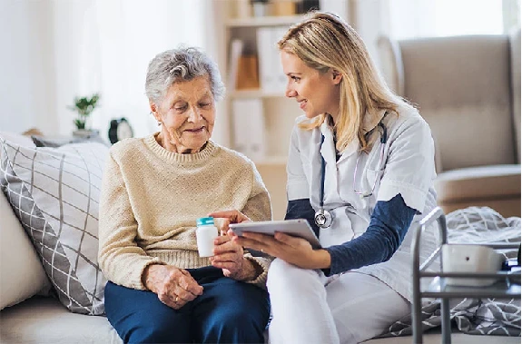 A caregiver at Elite Care Assisted Living in Lakeland, Florida, providing personal support and medication guidance to a senior resident.