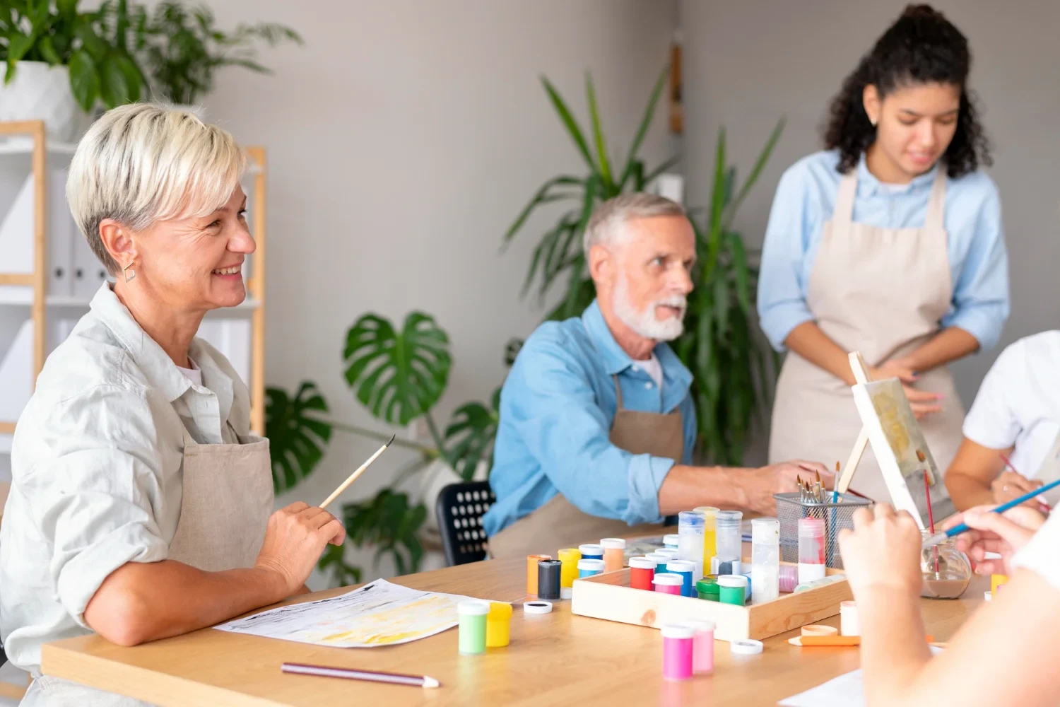 Residents enjoying arts and crafts activities with a caregiver in a lively and interactive environment.